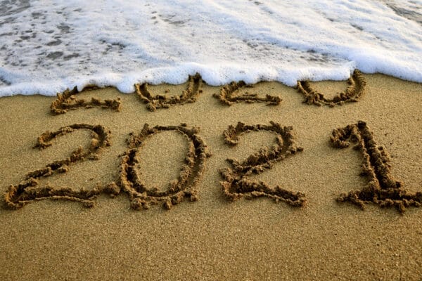 New year 2021 and 2020 on sandy beach with waves