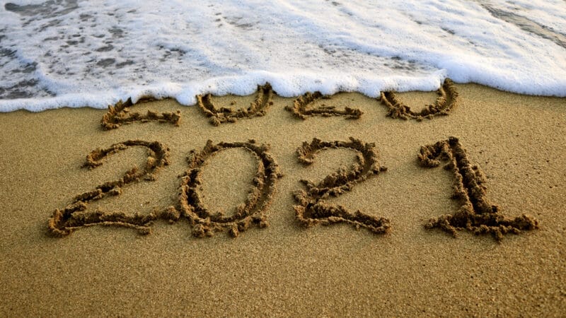 New year 2021 and 2020 on sandy beach with waves